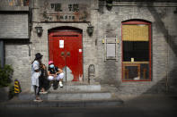 People wearing face masks to protect against the spread of the new coronavirus sit along a pedestrian shopping street in Beijing, Saturday, May 16, 2020. According to official data released on Saturday India's confirmed coronavirus cases have surpassed China's. (AP Photo/Mark Schiefelbein)