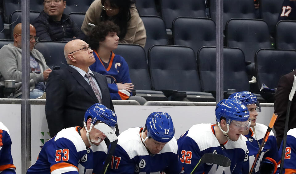 New York Islanders head coach Barry Trotz looks at the score board after the Carolina Hurricanes scored two empty net goals during the third period of an NHL hockey game, Sunday, Apr. 24, 2022, in New York. (AP Photo/Noah K. Murray)