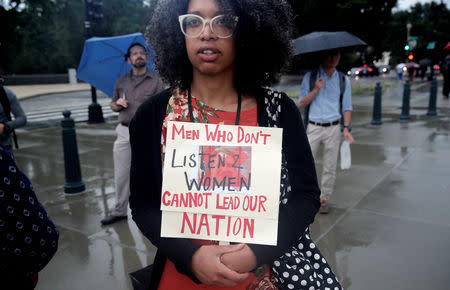 A demonstrator against the confirmation of Supreme Court nominee Judge Brett Kavanaugh, who refused to give her name, holds a sign reading "Men Who Don't Listen 2 Women Cannot Lead Our Nation," as she protests outside the U.S. Supreme Court building in the wake of a woman's accusation that Kavanaugh sexually assaulted her 36 years ago, on Capitol Hill in Washington, U.S., September 17, 2018. REUTERS/Mike Segar