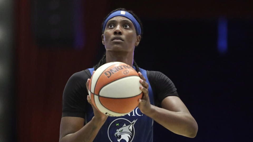 Minnesota Lynx center Sylvia Fowles holding the ball ready to shoot with a dark background.