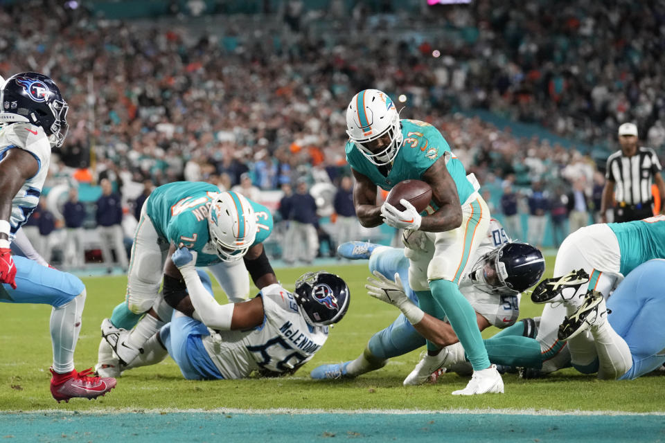 Miami Dolphins running back Raheem Mostert (31) runs for a touchdown as Tennessee Titans linebacker Jack Gibbens (50) attempts to stop him during the second half of an NFL football game, Monday, Dec. 11, 2023, in Miami. (AP Photo/Rebecca Blackwell)