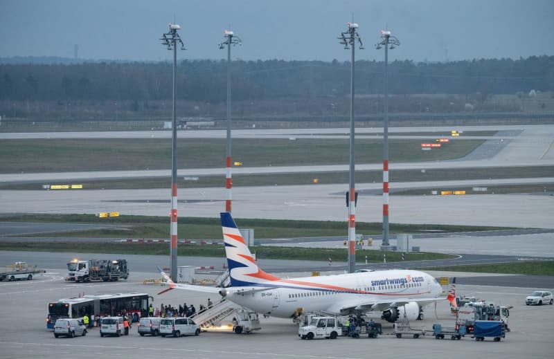 Passengers on the Smartwings.com Boeing 737 MAX 8 arriving from Islamabad via Dubai make their way to the buses at the back of the apron at Berlin Brandenburg Airport (BER). A group of Afghans with an acceptance letter for Germany landed in Berlin on Thursday evening. Soeren Stache/dpa