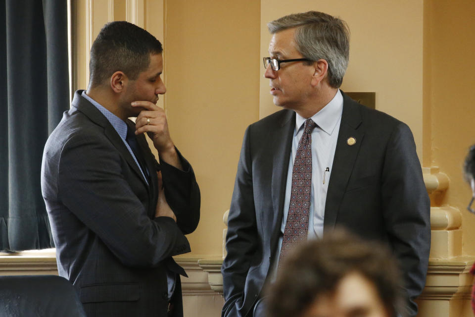 Del. Richard 'Rip' Sullivan, D-Arlington, right, talks with Del. Sam Rasoul, D-Roanoke, during the House session at the Capitol Thursday, March 5, 2020, in Richmond, Va. Sullivan is leading the floor debate on the renewable energy bills. (AP Photo/Steve Helber)