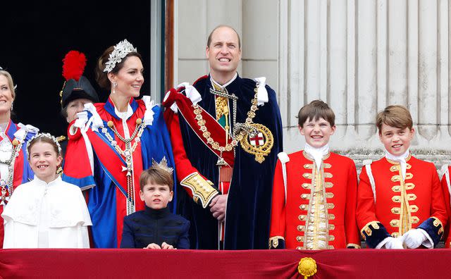 <p>Max Mumby/Indigo/Getty</p> Princess Charlotte of Wales, Catherine, Princess of Wales (wearing the Mantle of the Royal Victorian Order), Prince Louis of Wales, Prince William, Prince of Wales (wearing the Mantle of the Order of the Garter), Page of Honour Ralph Tollemache and Prince George of Wales (in his role as Page of Honour) watch an RAF flypast from the balcony of Buckingham Palace following the Coronation of King Charles III & Queen Camilla at Westminster Abbey on May 6, 2023 in London, England.