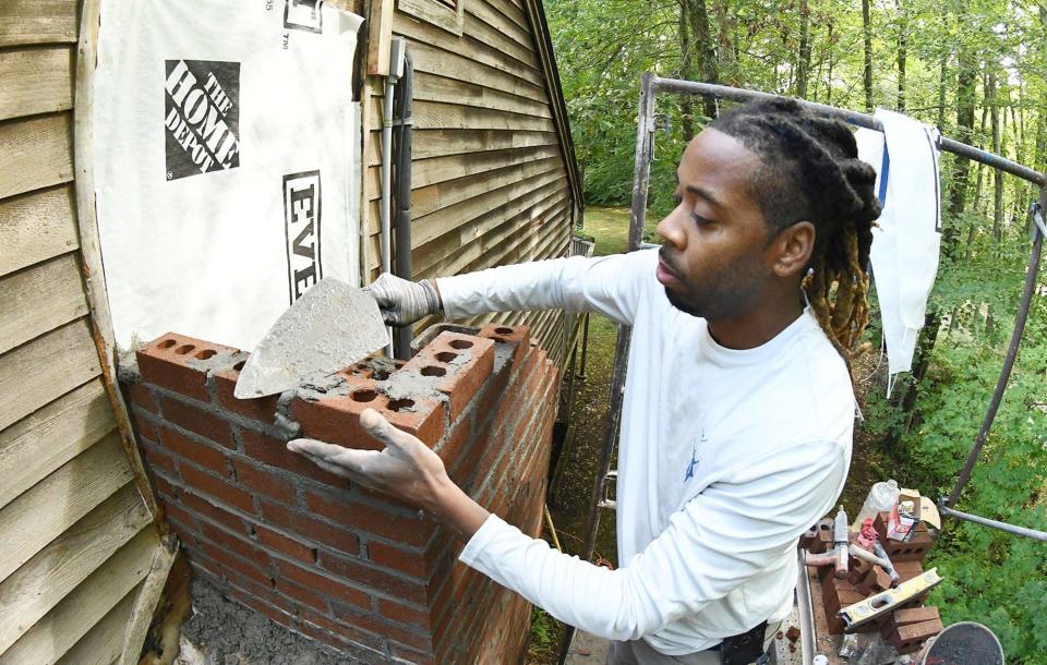 Jesse Baier of Colchester, co-owner of JLS Premier Masonry & Construction in Colchester, works on replacing a chimney in Colchester Sept. 8.