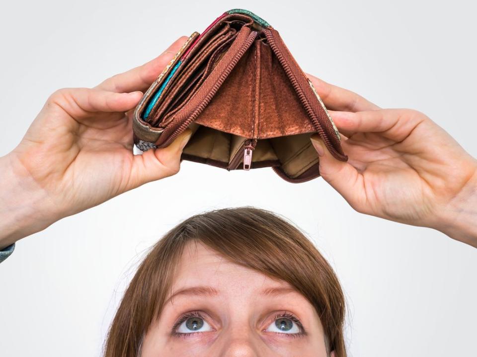 Woman holding an empty wallet, she hasn't money