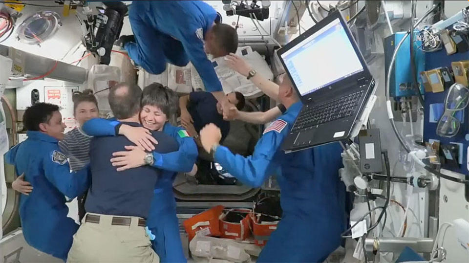 Crew-4 astronaut Samantha Cristoforetti hugs Crew-3 commander Tom Marshburn as their crewmates mingle following Crew-4's arrival at the space station. / Credit: NASA