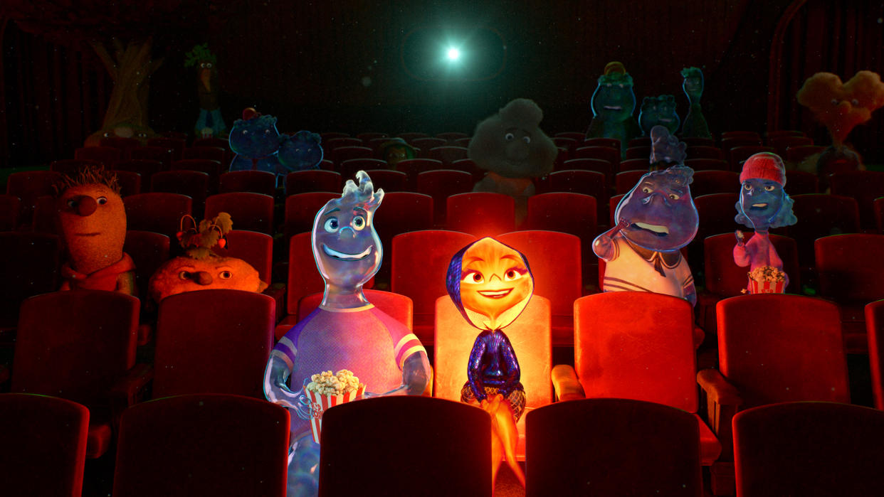  Wade and Ember sit down with popcorn to watch a movie in Pixar's Elemental. 