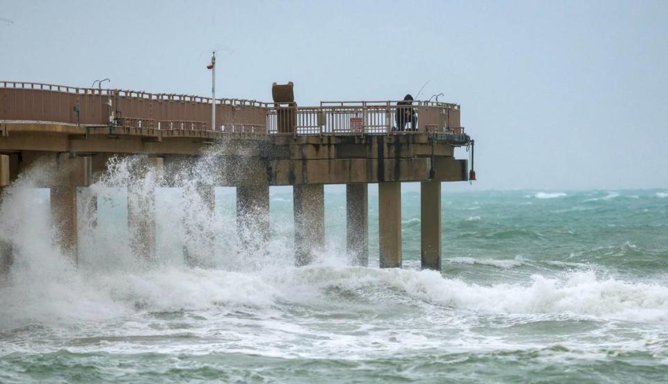 A person fishing at the Newport Fishing Pier in Sunny Isles Beach on Thursday, Dec. 14, 2023, as the gusty winds, heavy rain, flooded streets and other hazards are expected continue over the weekend in Miami, Fort Lauderdale and Palm Beach.