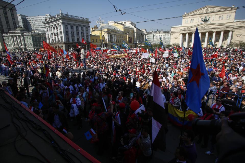 Thousands of Communists gather in downtown Moscow after the May Day march, Thursday, May, 1, 2014. About 100,000 people marched through Red Square to celebrate May Day, the first time the annual parade has been held on the vast cobblestoned square outside the Kremlin since the fall of the Soviet Union in 1991. The Bolshoi Theater is at the background, right. (AP Photo/Denis Tyrin)