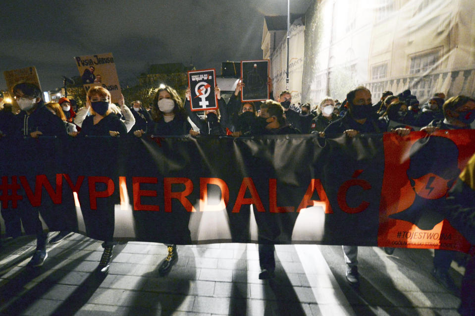 Young people take part in a protest against the conservative government, on the eighth straight day of angry demonstrations that were triggered by a recent tightening of the abortion law, in the Old Town, in Warsaw, Poland, Friday, Oct. 30, 2020.(AP Photo/Czarek Sokolowski)