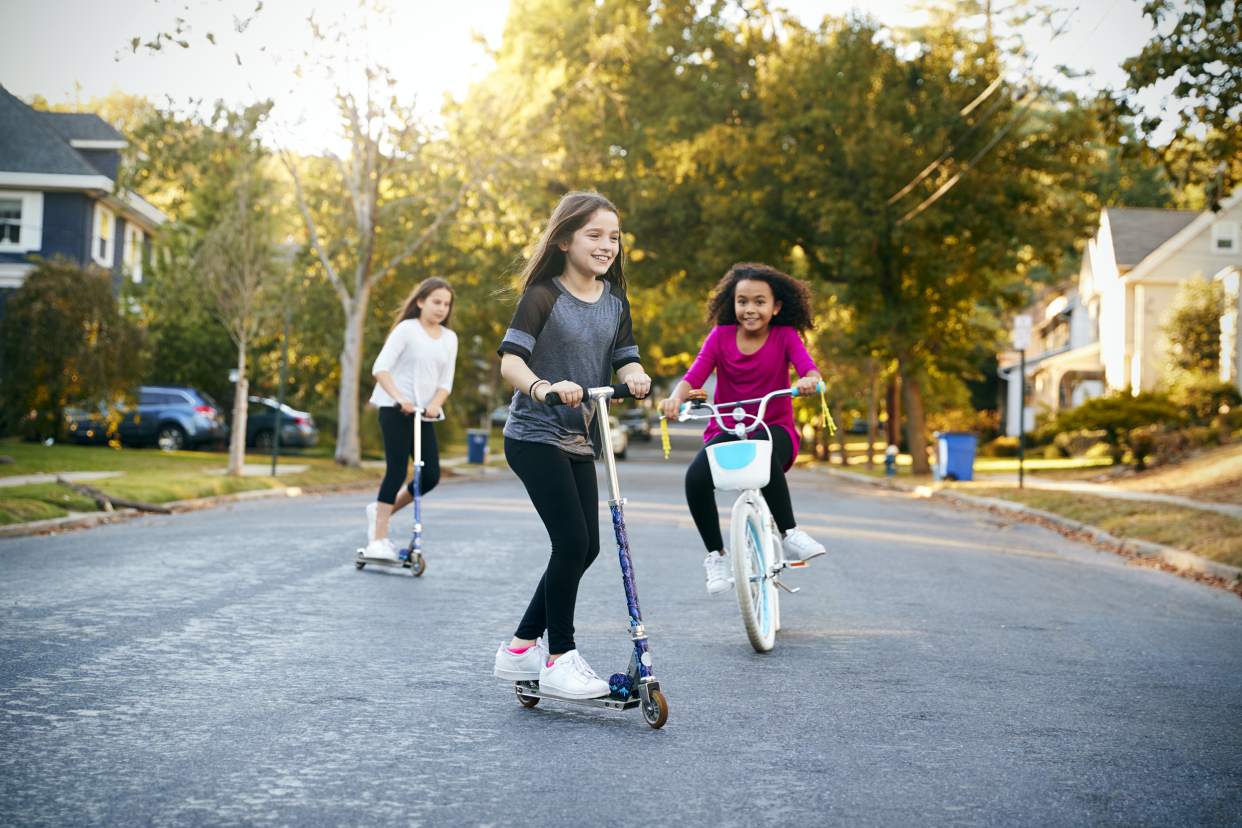 Kids riding bikes and scooters in the neighborhood