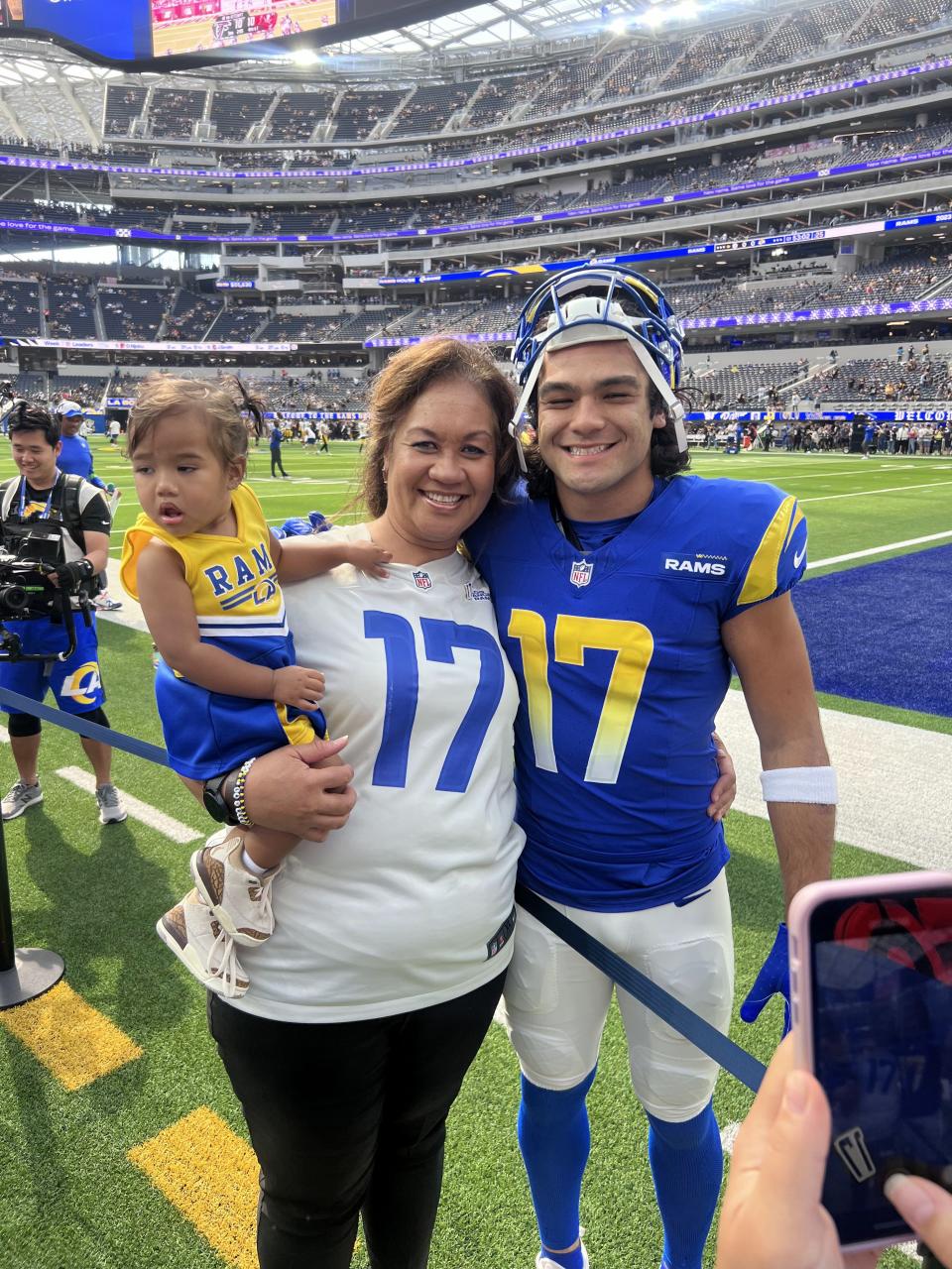 Rams receiver Puka Nacua poses for a picture with his mom, Penina, and her granddaughter, Coco Laulile, at SoFi Stadium in Los Angeles. It was the first NFL game Penina had ever attended. | Nacua family