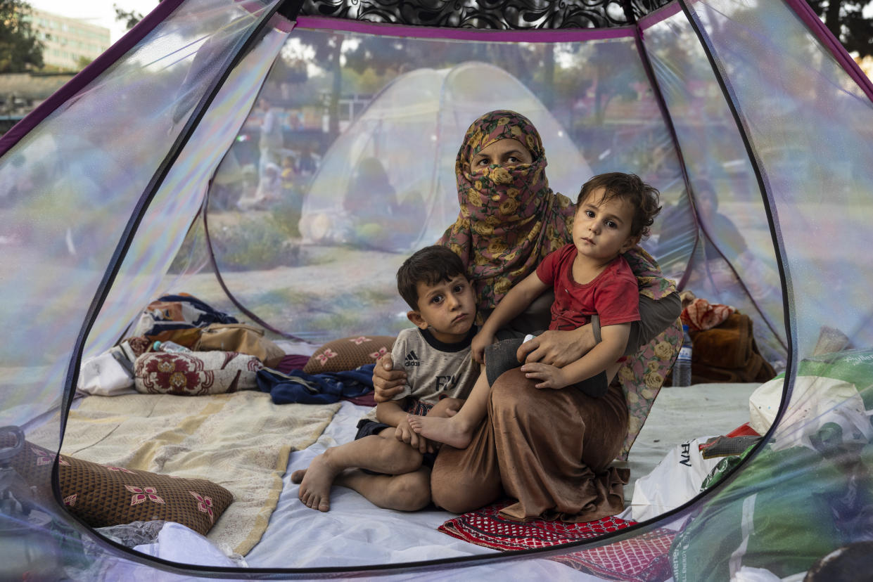 Farzia, 28, who lost her husband in Baghlan one week ago to fighting by the Taliban sits with her children, Subhan, 5, and Ismael ,2,  in a tent at a makeshift IDP camp in Share-e-Naw park to various mosques and schools on August 12, 2021 in Kabul, Afghanistan. (Paula Bronstein/Getty Images)