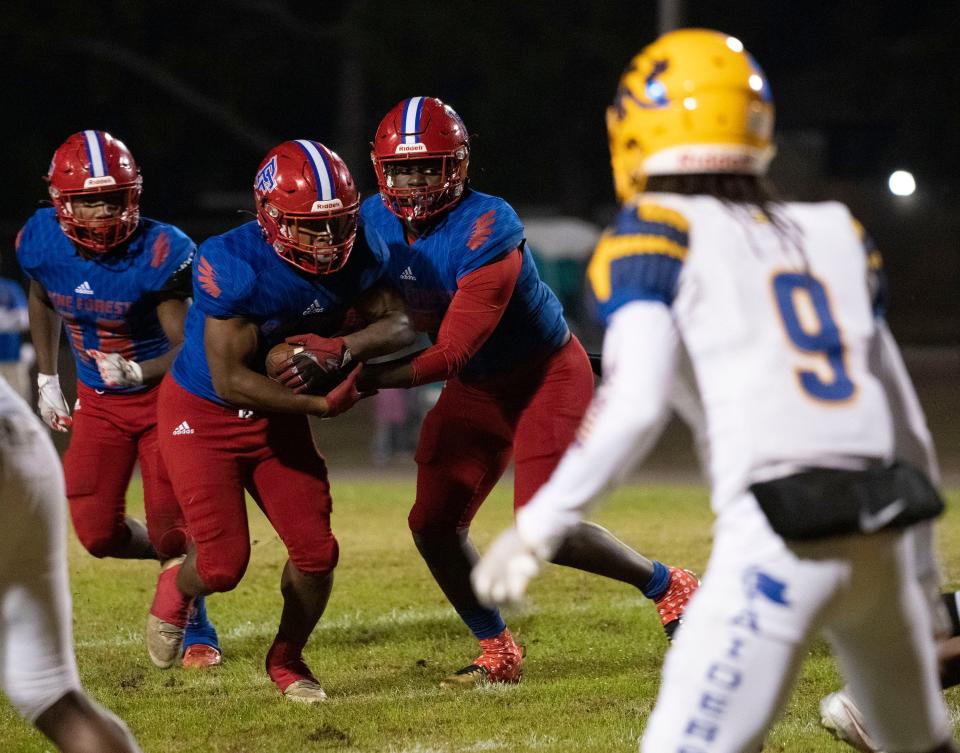 Pine Forest running back Kobe Johnson (No. 4) takes the handoff from quarterback Tierra Wilson (No. 5) during Friday night's 6-A regional quarterfinals game against Rickards. 