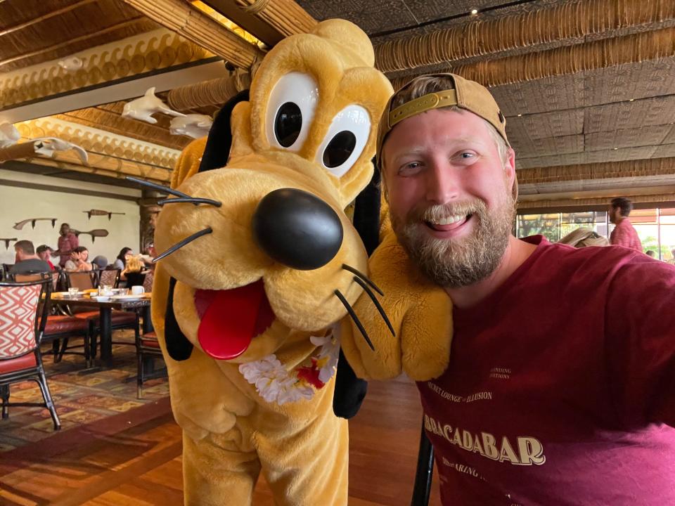 Author poses with Pluto character at 'Ohana.