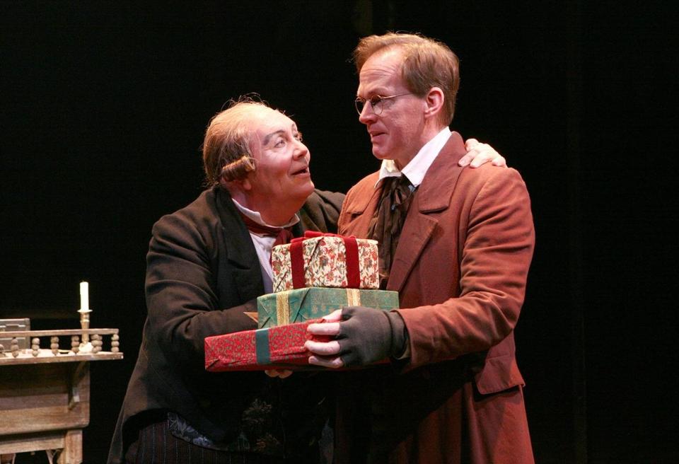 A reformed Ebenezer Scrooge (David Coffee) shocks Bob Cratchit (Russell Garrett) with gifts in a scene from "A Christmas Carol" at North Shore Music Theatre.