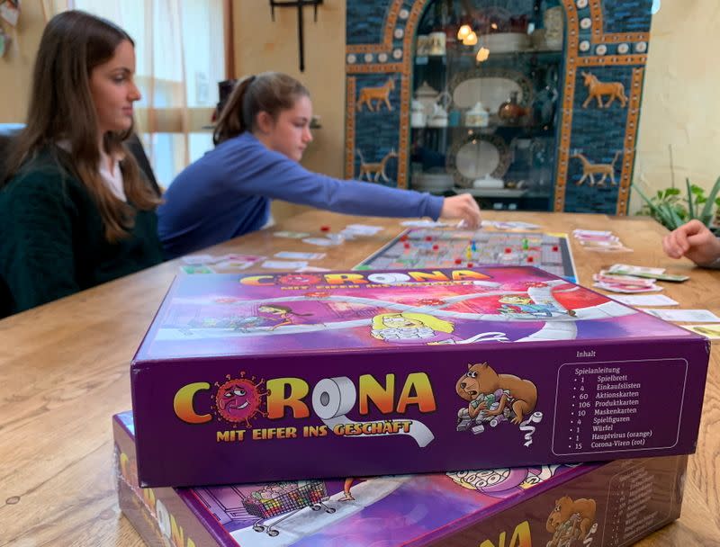 Rebecca, Lara, Stella y Sarah Schwaderlapp juegan 'Corona - el juego de mesa de la carrera hacia las tiendas' inventado por Lara y Sarah para pasar el tiempo encerrados, en Wiesbaden Biebrich, Alemania