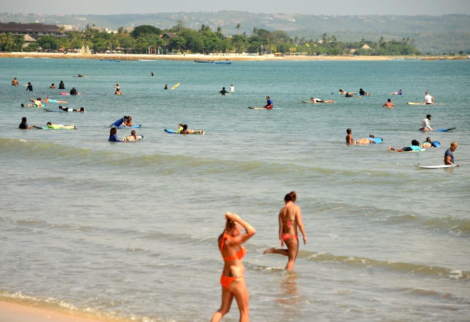 Tourists surf at Kuta beach near Denpasar on Indonesia's resort island of Bali.