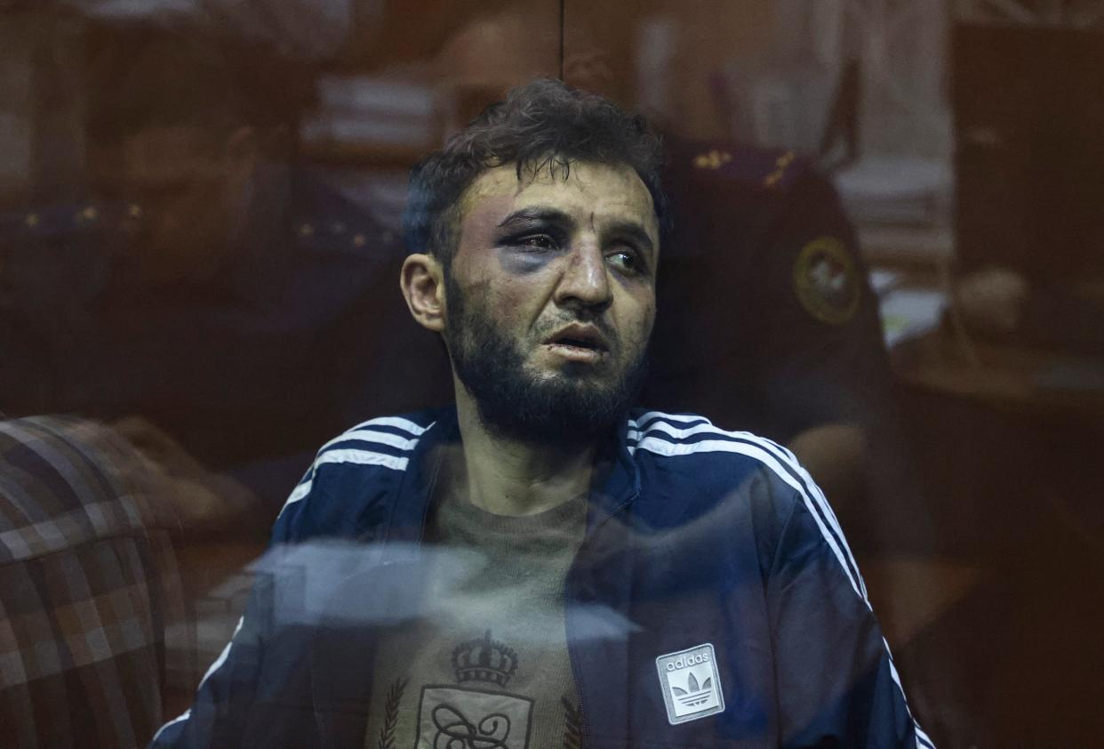 Dalerdzhon Mirzoyev, a suspect in the shooting attack at the Crocus City Hall concert venue, sits behind a glass wall of an enclosure for defendants at the Basmanny district court in Moscow (EPA)