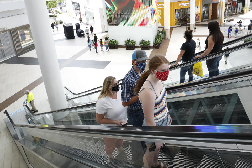 FILE - In this May 29, 2020, file photo, people wearing face masks take an escalator to the second floor of the Arden Fair Mall in Sacramento, Calif. Gov. Gavin Newsom's administration on Thursday, June 18, 2020, mandated that Californians wear masks in most indoor settings as the state continues to battle the coronavirus. (AP Photo/Rich Pedroncelli, File)