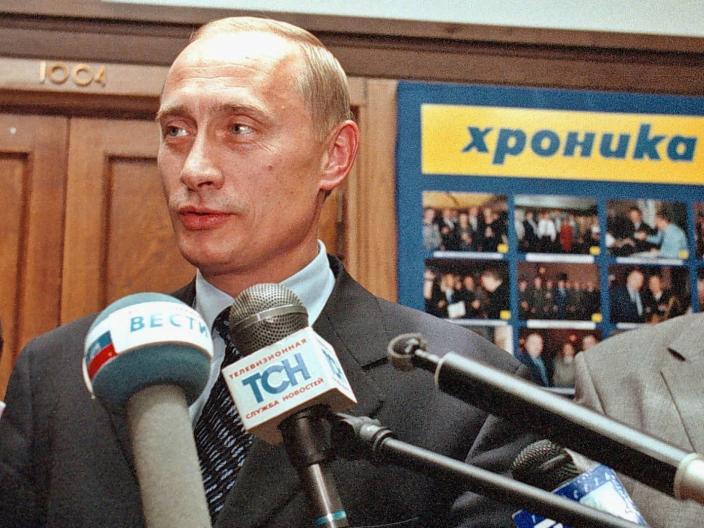 Then-Acting Russian Prime Minister Vladimir Putin speaking to the media, with ultranationalist leader Vladimir Zhirinovsky in the background, in Moscow, 12 August 1999