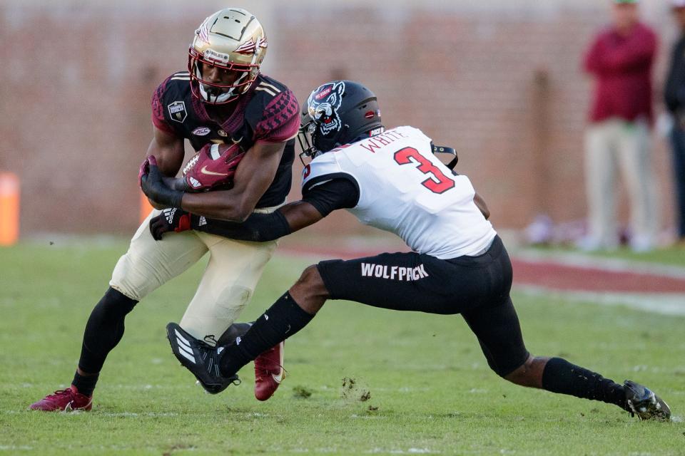 Florida State Seminoles wide receiver Malik McClain (11) tries to avoid a tackle. The Florida State Seminoles lost to the North Carolina State Wolfpack 14-28 Saturday, Nov. 6, 2021.