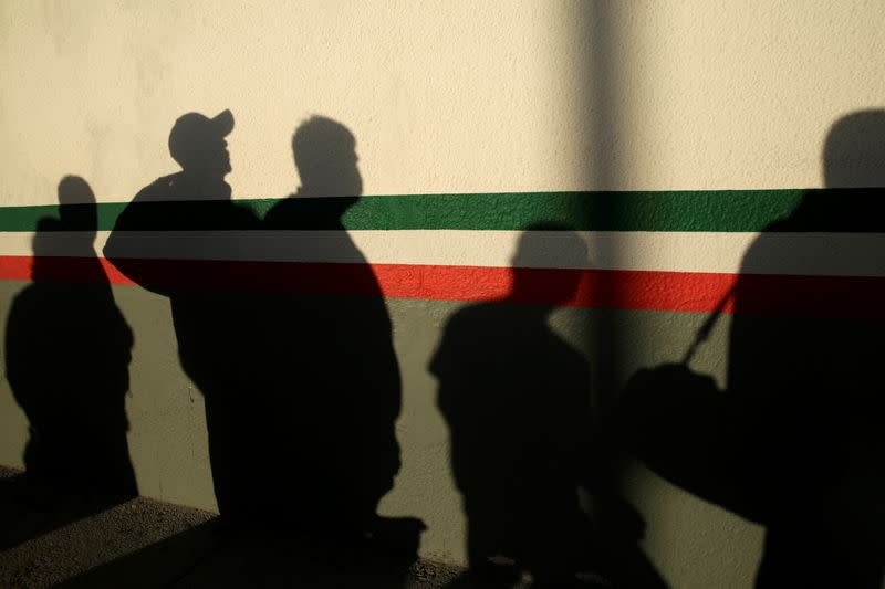 Mexican immigrants cast shadows on a National Institute of Migration (INM) building after they were deported from the United States and crossed the Paso del Norte border bridge amid the spread of the coronavirus disease (COVID-19), in Ciudad Juarez