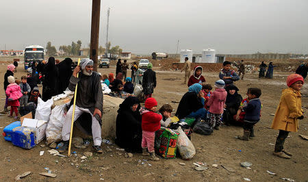 Displaced Iraqi people who fled their homes during a battle between Iraqi forces and Islamic State militants, gather at a checkpoint to be transfer to Hammam al-Alil camp, in Mosul, Iraq, March 20, 2017. REUTERS/Thaier Al-Sudani