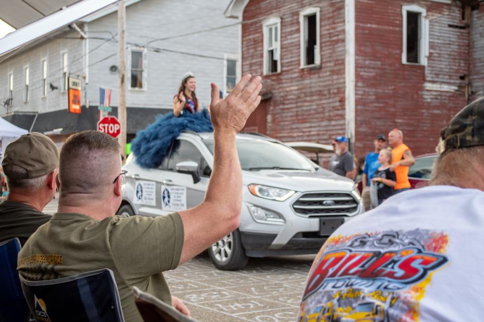 Guernsey County Sheriff Jeff Paden waves to the Cy Young Junior Queen Attendant Gretchin Rolli during the Queen's Parade in Quaker City.