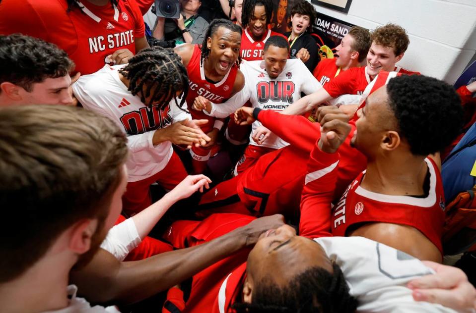 The Wolfpack players celebrate after putting their sticker on the wall after N.C. State’s 72-65 overtime victory over Virginia in the semifinals of the 2024 ACC Men’s Basketball Tournament at Capital One Arena in Washington, D.C., Friday, March 15, 2024.