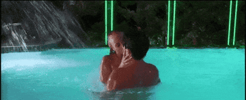 couple kissing in the pool at night