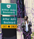 Richmond Mayor Levar Stoney claps after unveiling the he Arthur Ashe Blvd. signs during a renaming the boulevard ceremony at the Virginia Museum of History and Culture in Richmond, Va., Saturday, June 22, 2019. (Alexa Welch Edlund/Richmond Times-Dispatch via AP)