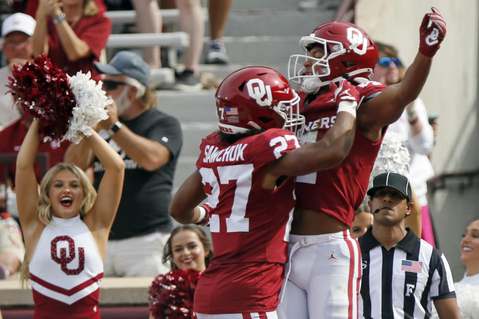 Oklahoma running back Gavin Sawchuk (27) and wide receiver Nic Anderson, right, celebrate after a touchdown reception by Anderson against Central Florida in the first half of an NCAA college football game, Saturday, Oct. 21, 2023, in Norman, Okla. (AP Photo/Nate Billings)