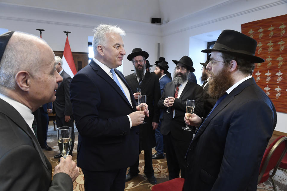 Deputy prime minister in charge of Hungarian communities abroad, church policy and national and ethnic minorities, Zsolt Semjen, centre, and Chief Rabbi of the Unified Israelite Congregation of Hungary (EMIH) Slomo Koves, right, attend a recepetion after signing a comprehensive agreement at the Castle District premises of the Prime Minister's Office, in Budapest, Hungary, Monday, Nov. 18, 2019. By signing the agreement, the Hungarian state acknowledges the historical traditions of the Jewish community and "EMIH's service to the renaissance of Hungary's Jewish community", Semjen said at the signing ceremony. (Szilard Koszticsak/MTI via AP)