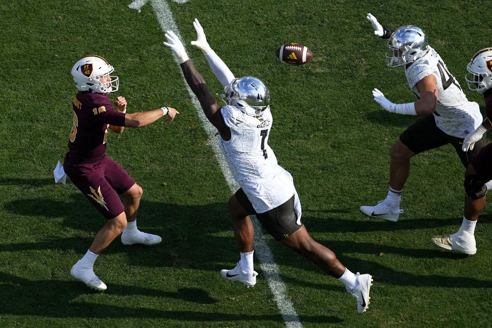 Arizona State quarterback Trenton Bourguet (16) throws under pressure from Oregon defensive end Jordan Burch, right, during the first half on an NCAA college football game, Saturday, Nov. 18, 2023, in Tempe, Ariz. (AP Photo/Matt York)