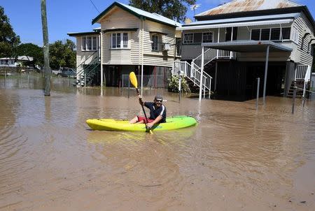 A local resident paddles his kayak through floodwaters in the wake of Cyclone Debbie in the suburb of Depot Hill in Rockhampton, Australia, April 5, 2017. AAP/Dan Peled/via REUTERS