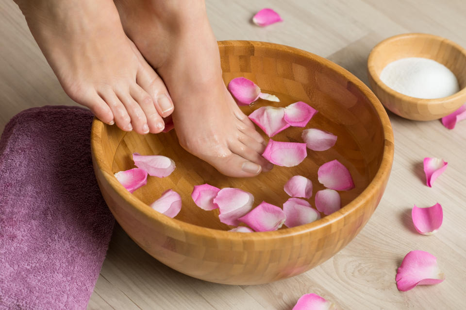 Woman soaking feet in rosewater after learning how to make rosewater