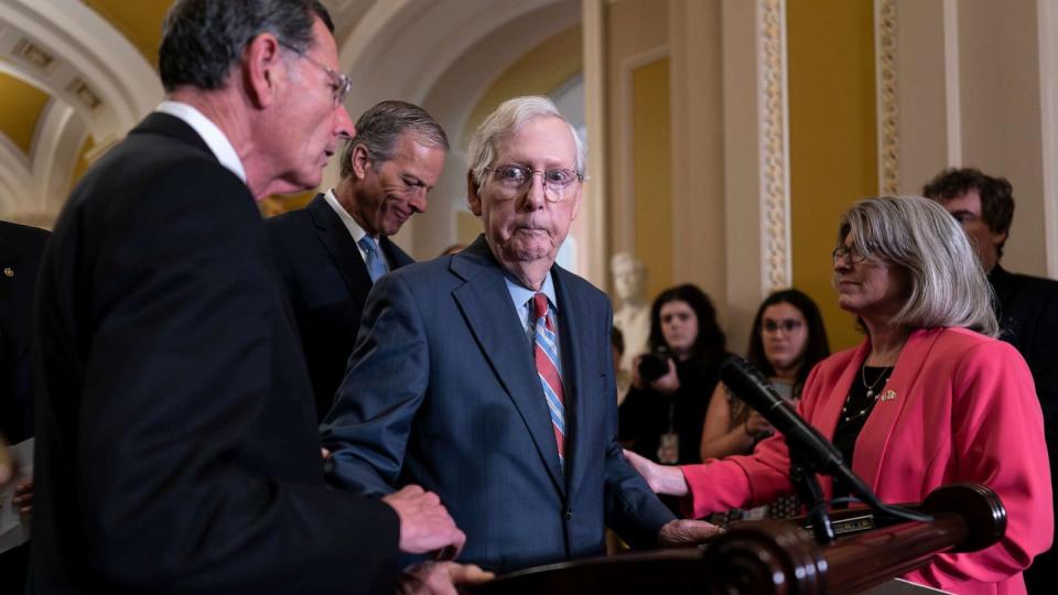 PHOTO: Senate Minority Leader Mitch McConnell is helped by, Sen. John Barrasso after the GOP leader froze at the microphones as he arrived for a news conference, at the Capitol in Washington, July 26, 2023. (J. Scott Applewhite/AP)