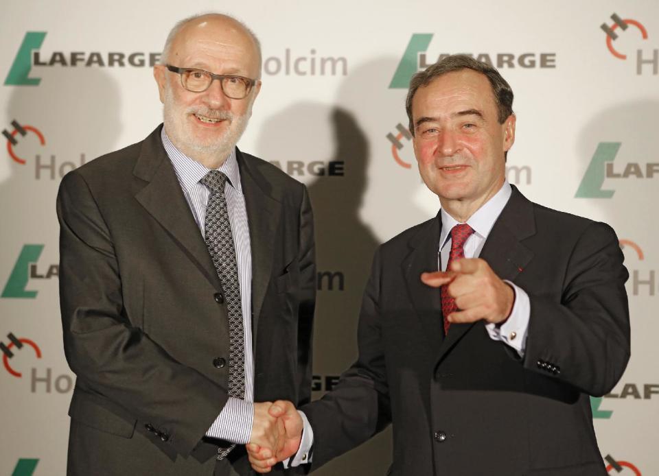 Bruno Lafont, right, chairman and chief executive of French cement maker Lafarge Group shakes hands with Swiss cement maker Holcim chairman Rolf Soiron during a press conference, Monday, April 7, 2014 in Paris. Lafont and Soiron announced plans for a "merger of equals" Monday that would create an industry giant with a combined euro32 billion (US$43.9 billion) in annual revenues. (AP Photo/Jacques Brinon)