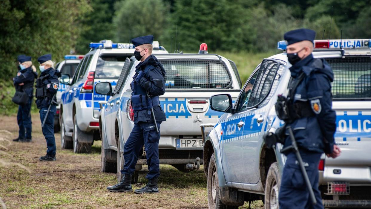 Polizeibeamte stehen an der polnisch-belarussischen Grenze.