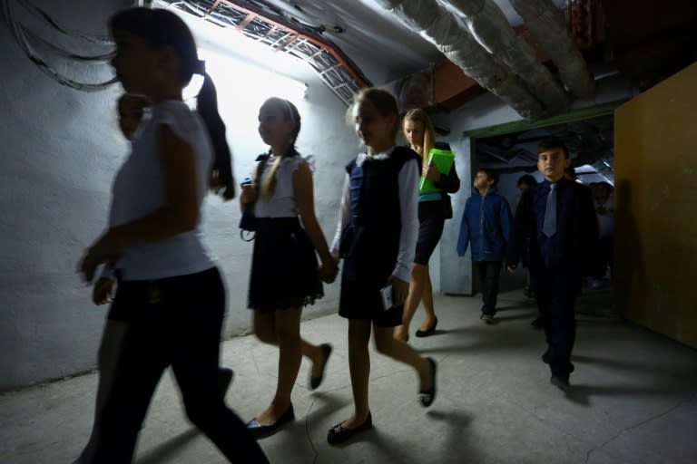 An alarm warns Ukrainian schoolchildren to make their way to a bomb shelter underground