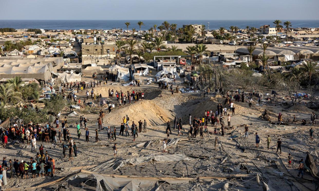 <span>People inspect craters left by Israeli airstrikes on al-Mawasi in the southern Gaza Strip.</span><span>Photograph: Haitham Imad/EPA</span>