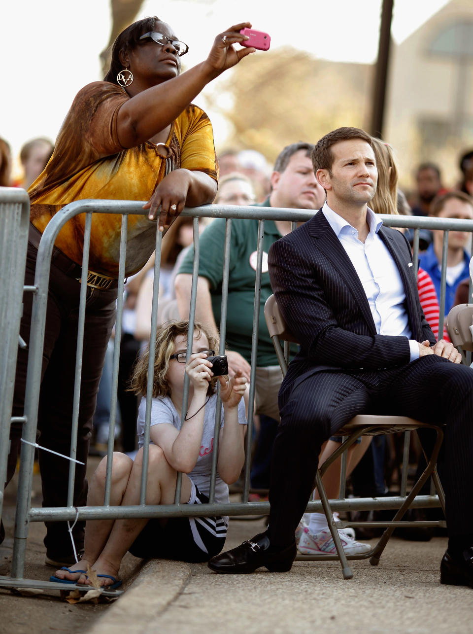 PEORIA, IL - MARCH 19: People take photographs as Rep. Aaron Schock (R-IL) listens to Republican presidential candidate, former Massachusetts Gov. Mitt Romney during a town-hall campaign meeting on the campus of Bradley University March 19, 2012 in Peoria, Illinois. Romney is campaigning in Illinois the day before that state’s primary elections, when 54 GOP delegates are up for grabs. With Romney in the lead on delegates, fellow candidate, former Pennsylvania Sen. Rick Santorum continues to compete for the 1,444 necessary to secure the nomination before the last primary, in Utah on June 26. (Photo by Chip Somodevilla/Getty Images)