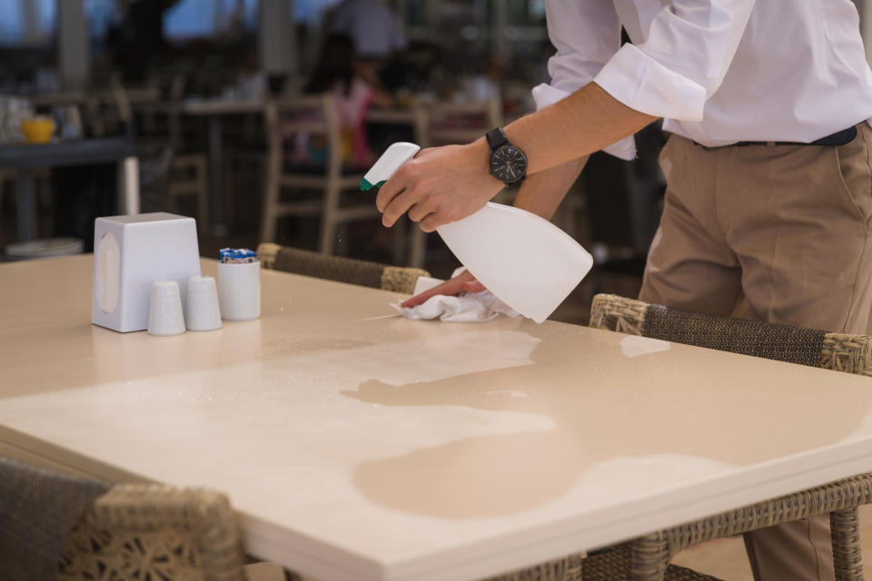 A waiter cleaning a table
