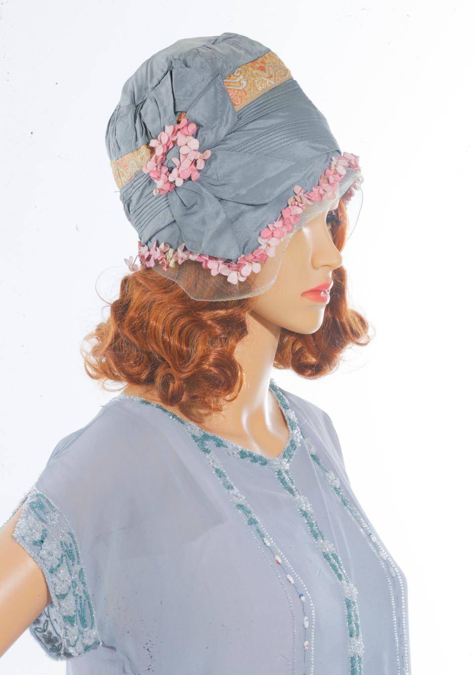 During the 1920s hemlines were on the rise and constrictive undergarmets were on the way out of favor.  The close fitting hat that was popular in the 1920s was called a 'cloche'  often they had floral trimming or feathers.  This outfit is from the Kentucky Gateway Museum Center in Maysville, Kentucky.