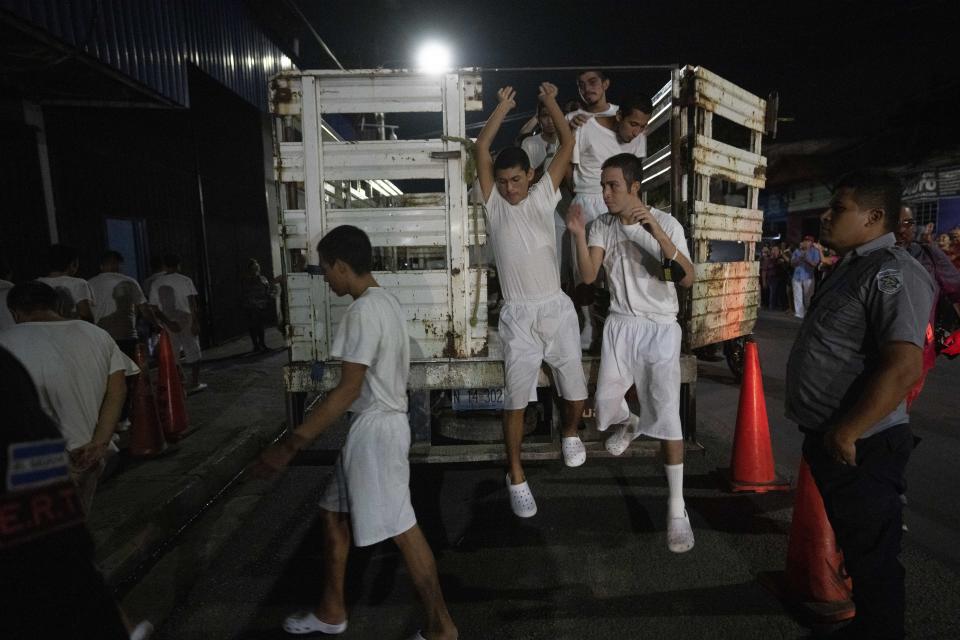 Men who were arrested under the ongoing "state of exception" step out of a cargo truck before being released, in San Salvador, El Salvador, late Friday, Oct. 14, 2022. With 55,000 people locked up since late March for alleged gang ties, El Salvador’s congress has approved another month-long extension of the state of exception that suspends some fundamental rights in the name of combatting the country’s powerful gangs. (AP Photo/Moises Castillo)