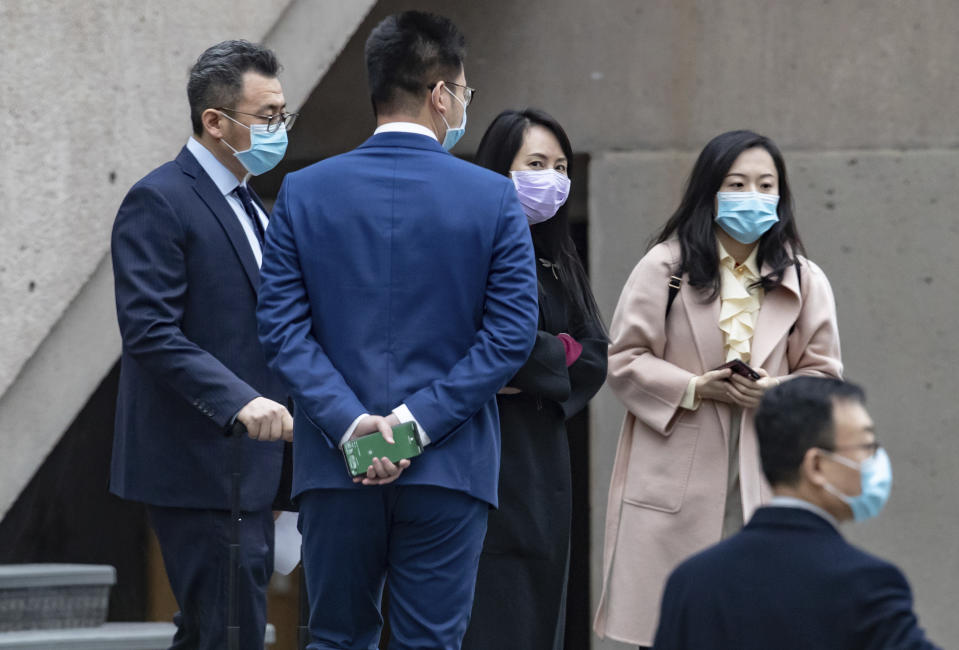 Chief Financial Officer of Huawei, Meng Wanzhou, third left, meets with colleagues during a break from a hearing at British Columbia Supreme Court, in Vancouver, British Columbia, Friday, March 19, 2021. (Darryl Dyck/The Canadian Press via AP)