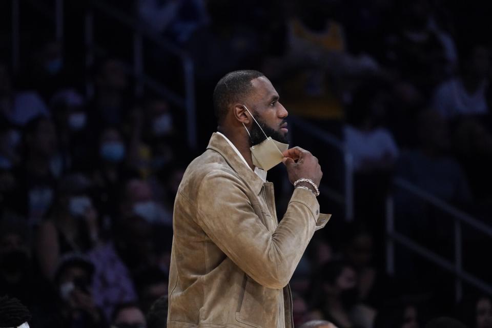LeBron James watches action from the bench in the first half of the Lakers' game against the Timberwolves on Nov. 12, 2021.