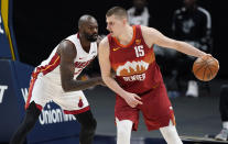 Denver Nuggets center Nikola Jokic is defended by Miami Heat center Dewayne Dedmon during the second half of an NBA basketball game Wednesday, April 14, 2021, in Denver. (AP Photo/David Zalubowski)